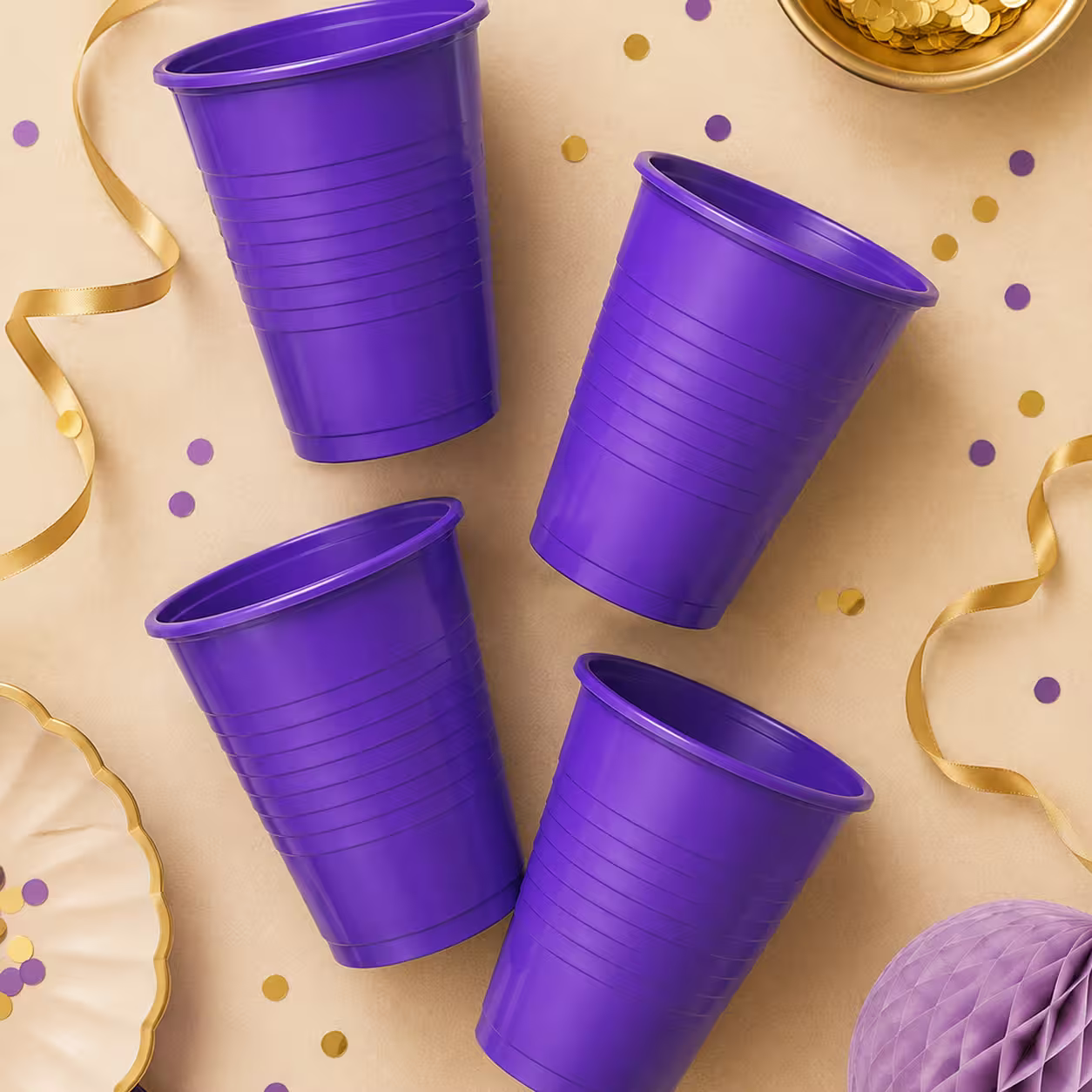 Pahare din plastic mov aranjate ca decor de petrecere