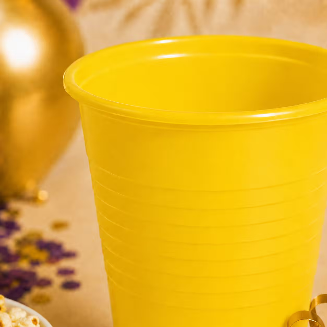 Detaliu cu pahar din plastic galben de unică folosință